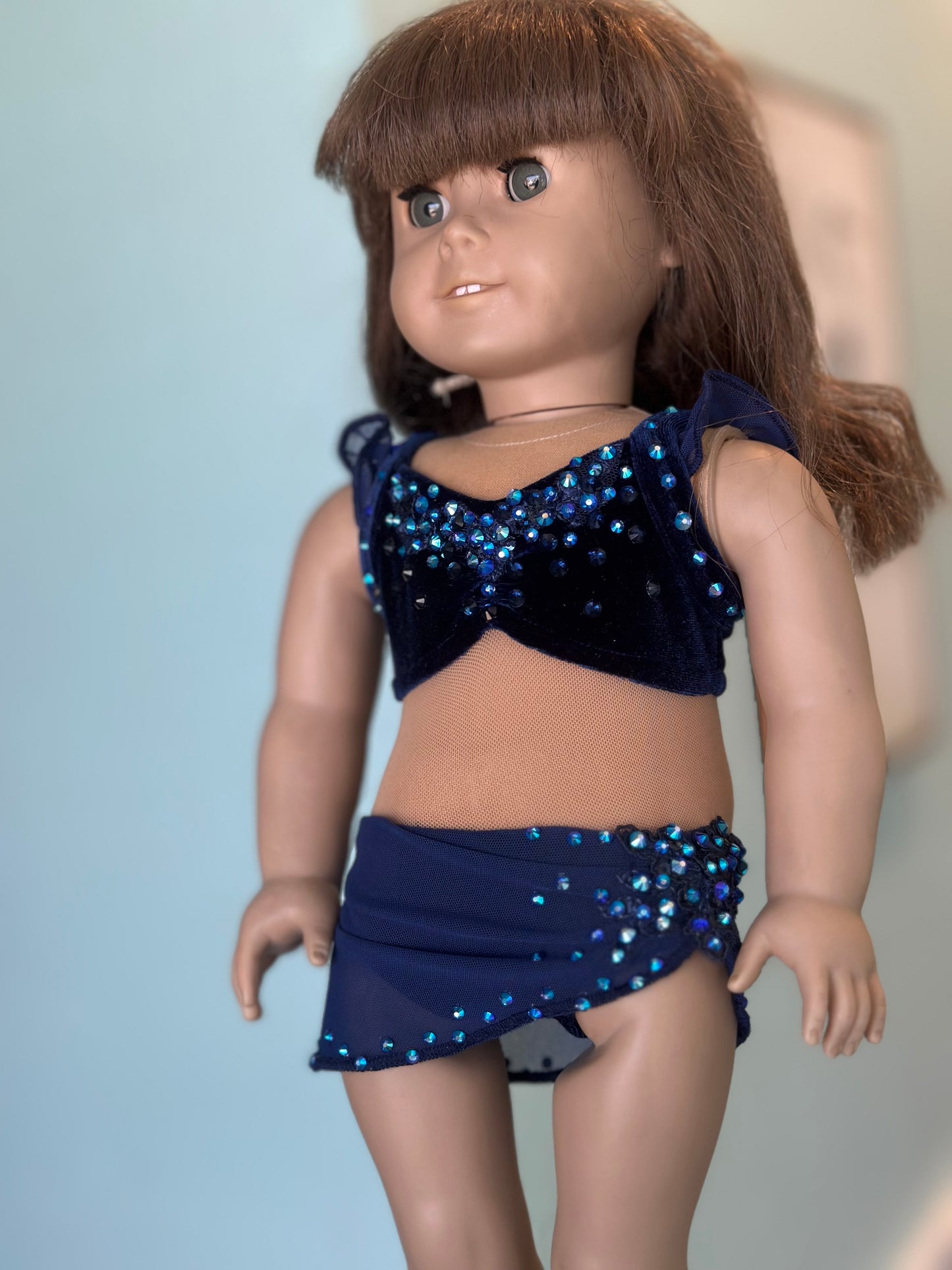 Doll wearing a navy blue sequin top and skirt against a plain background