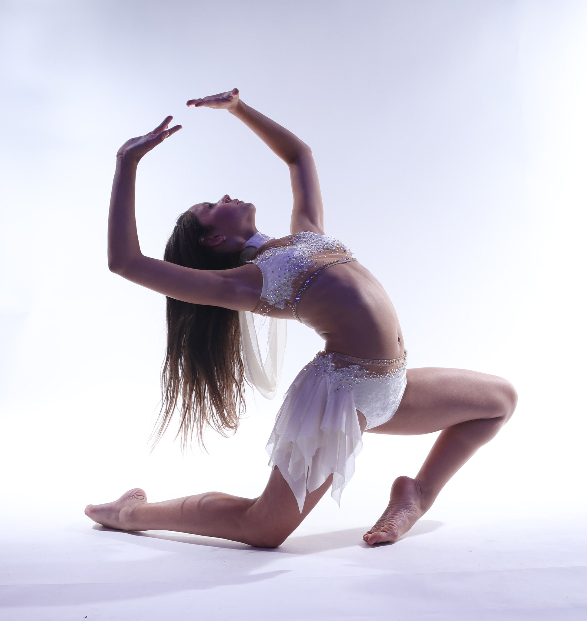 Dancer in a white custom dance costume performing on a light background