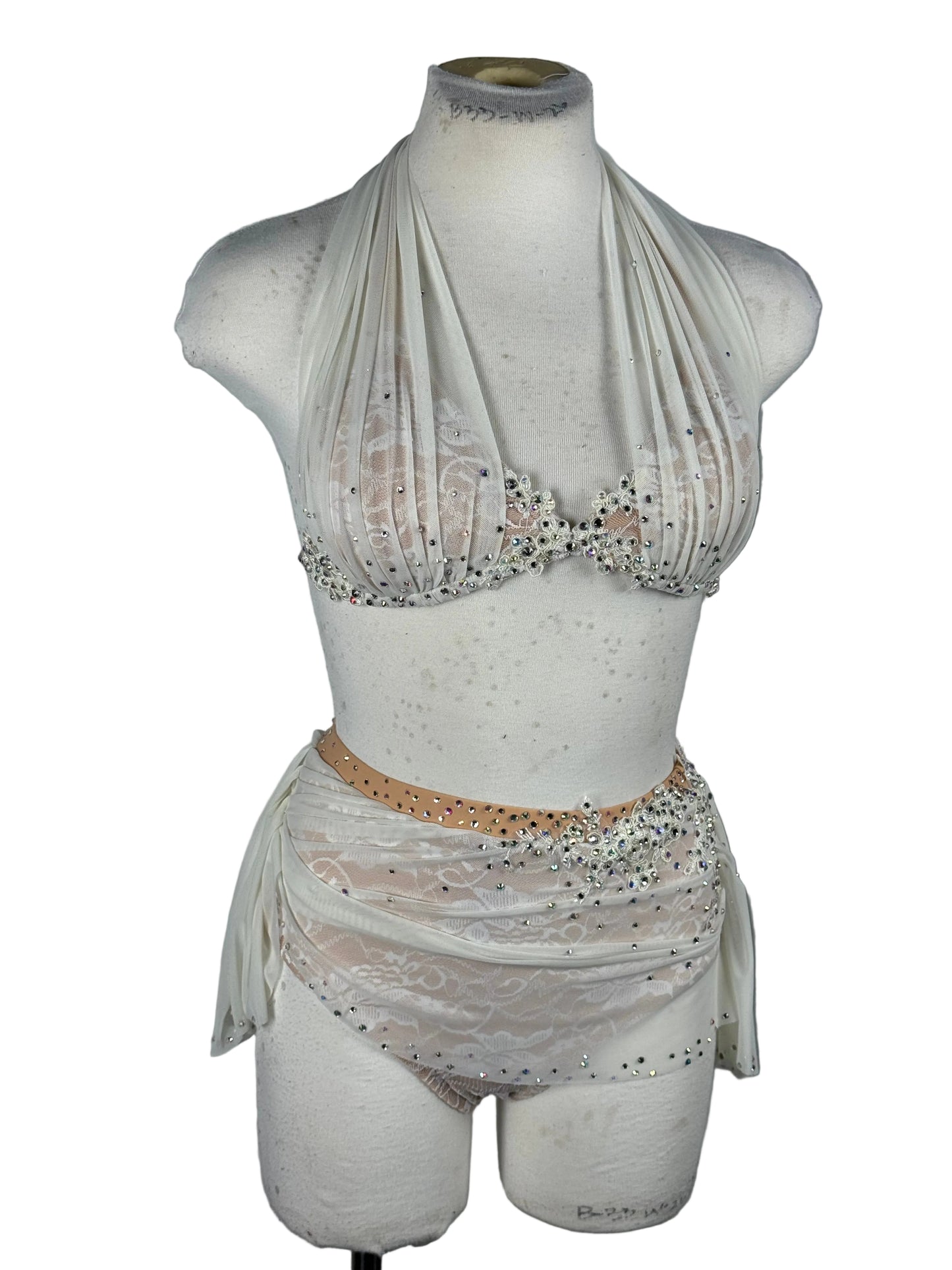 Mannequin torso wearing a white dress with lace details on a white background