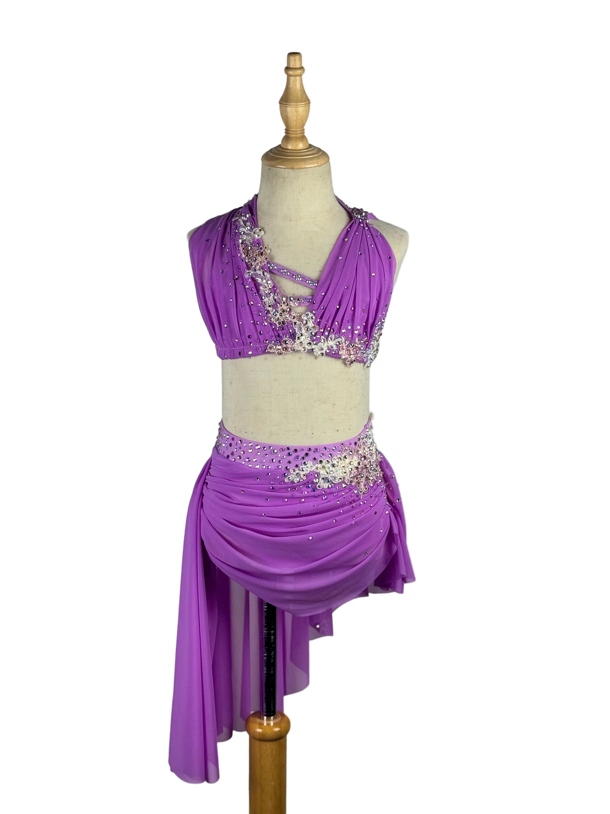Purple dance costume with embellishments on a mannequin against a white background