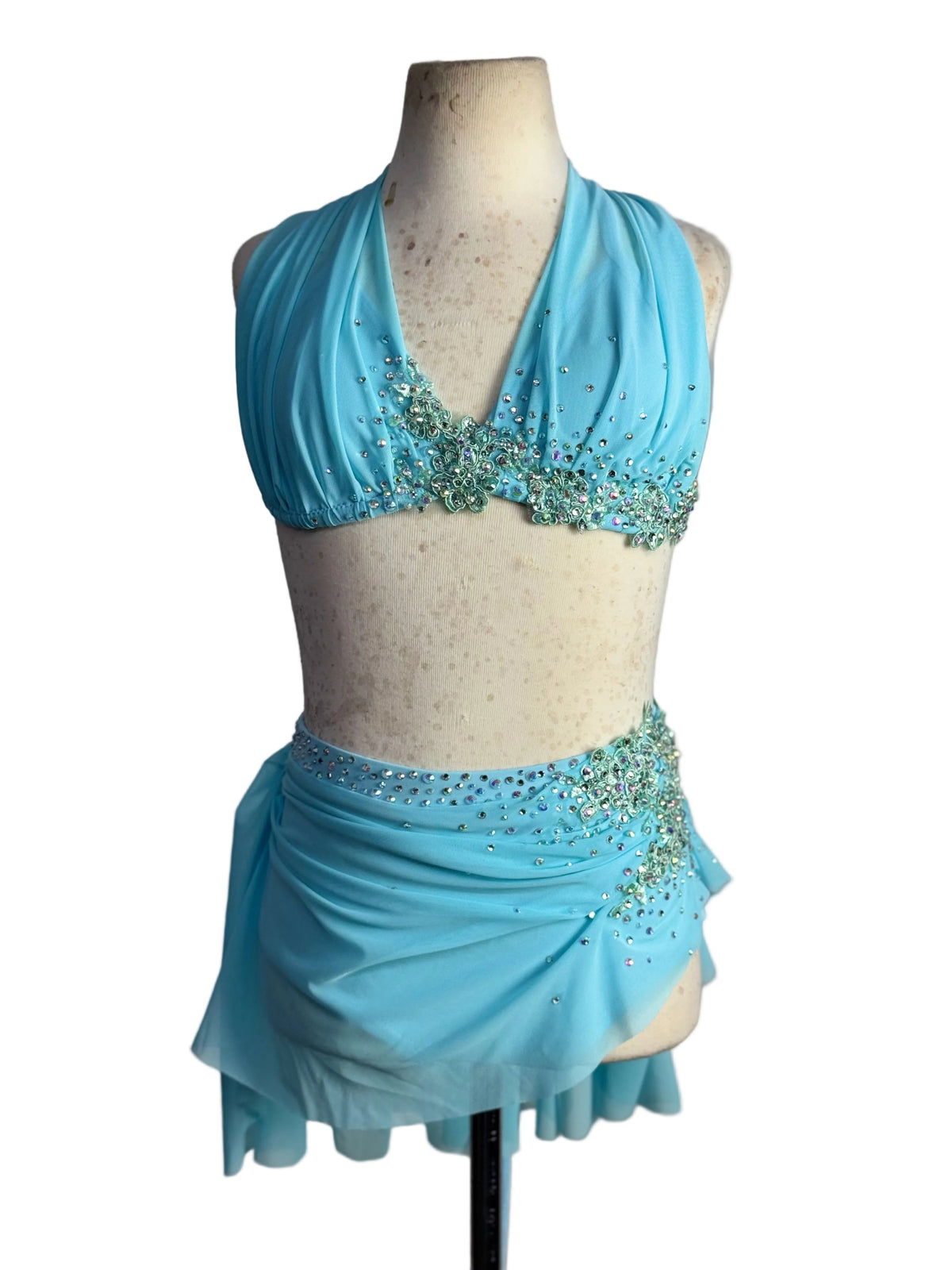 A light blue dance costume set displayed on a beige mannequin torso against a white background.