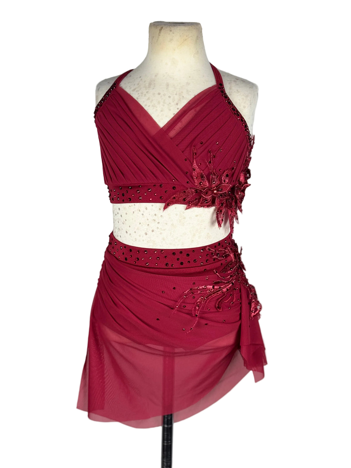 A two-piece dance costume set in deep burgundy red, displayed on a cream-colored mannequin torso against a white background.