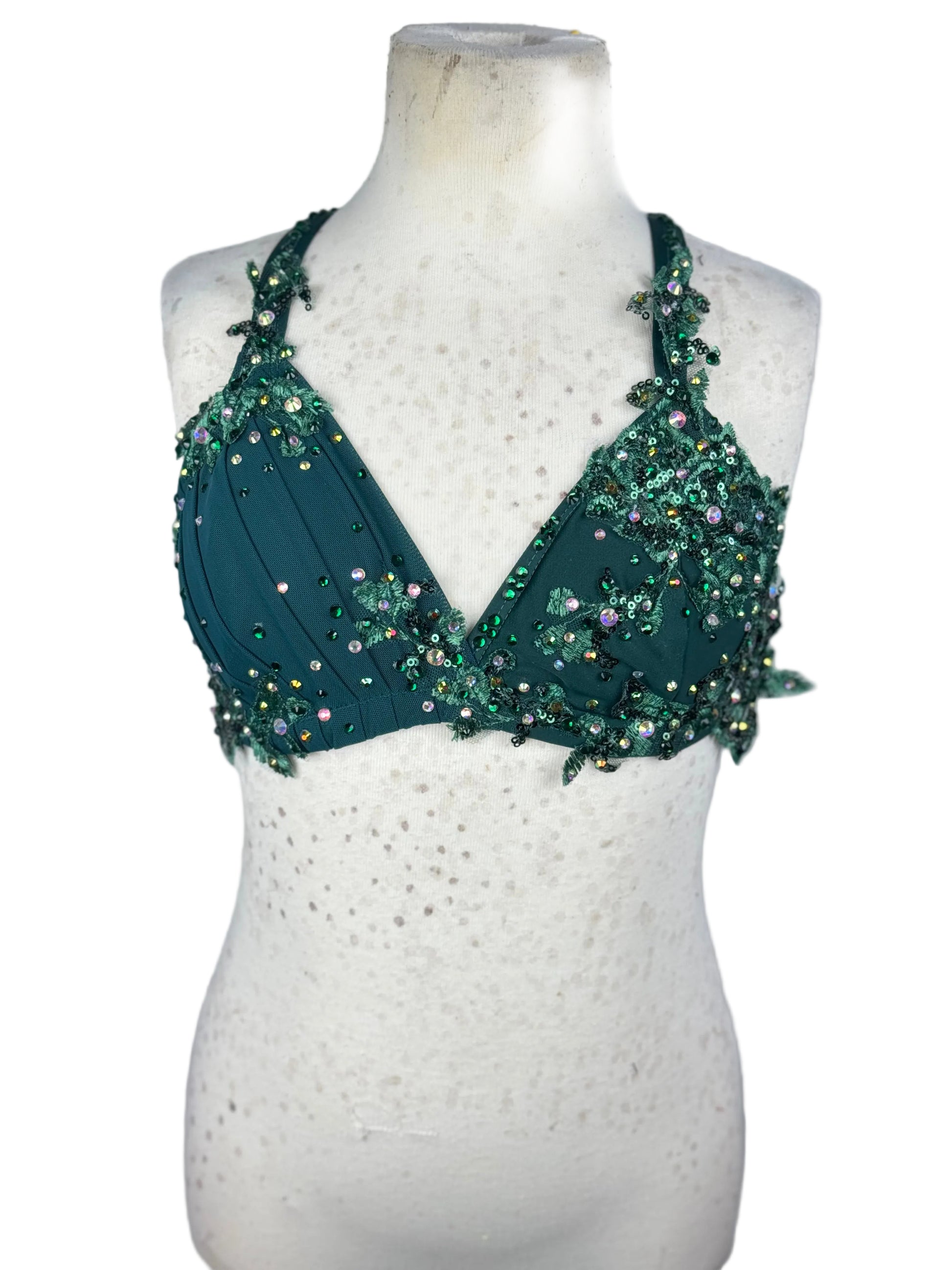 Green beaded bralette on a mannequin against a white background