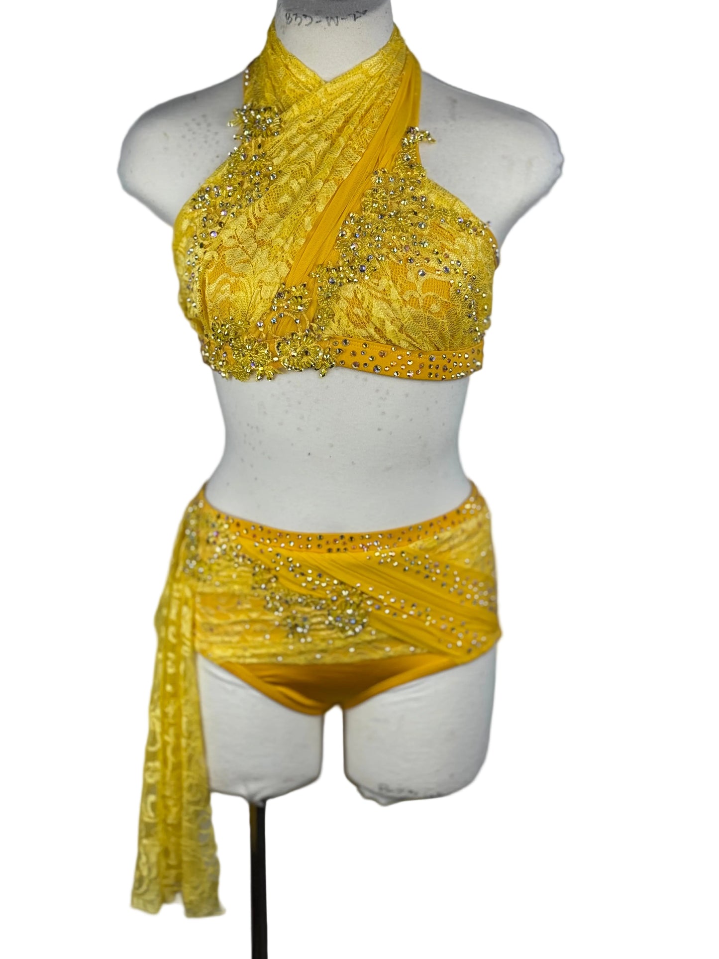 Yellow beaded top and skirt on a mannequin against a white background