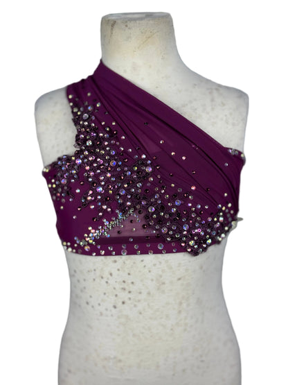 Purple one-shoulder top with sequins on a mannequin against a white background