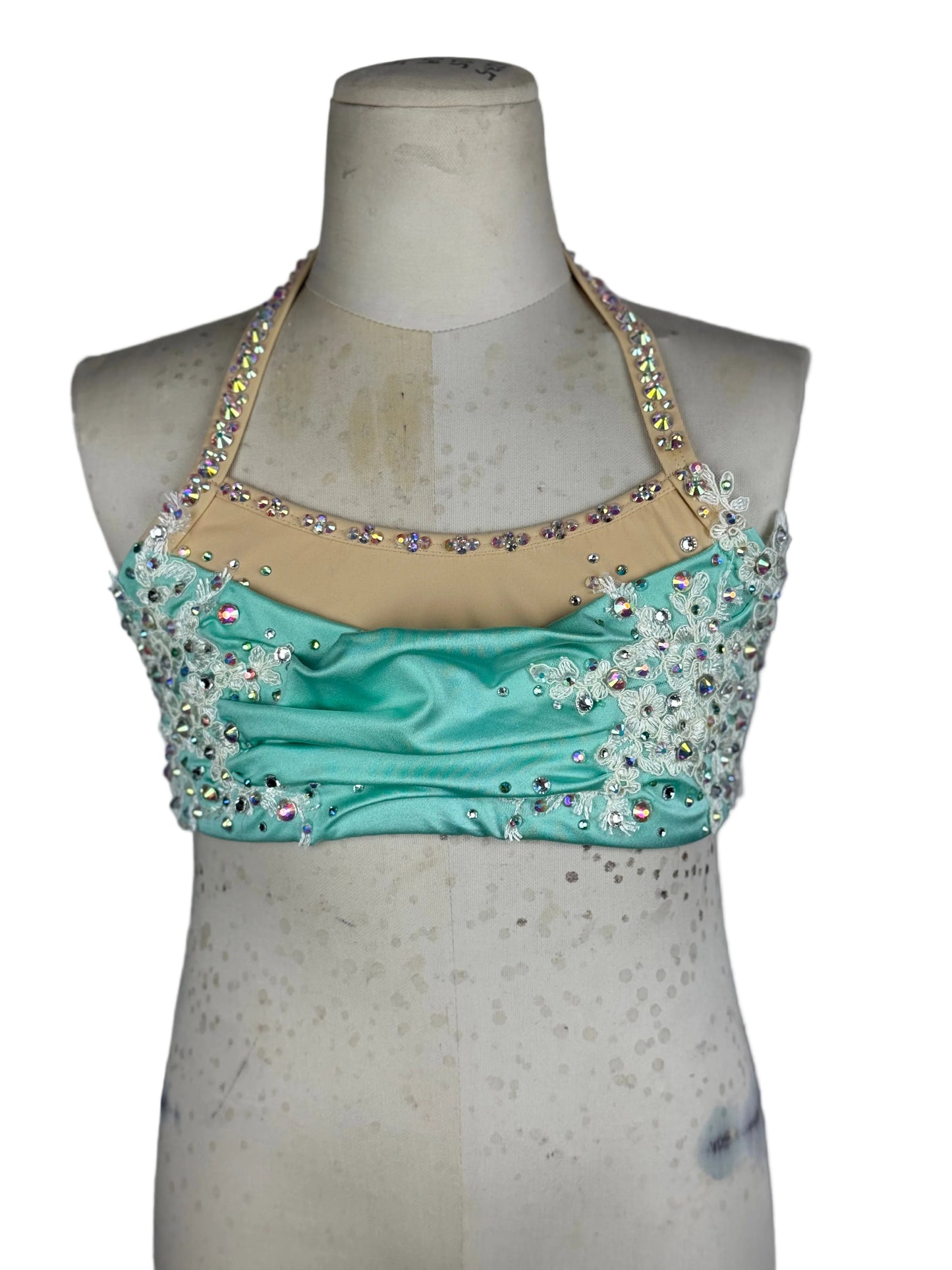 Mint top with bead embellishments on a mannequin against a white background