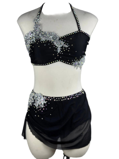 Black and silver lyrical dance costume with beaded top and skirt on a mannequin against a white background