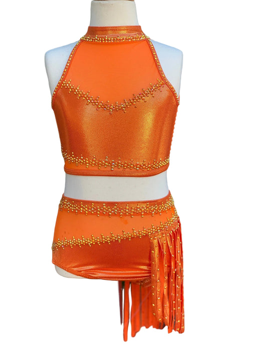 A bright orange metallic two-piece dance costume with rhinestones and fringe, displayed on a mannequin.